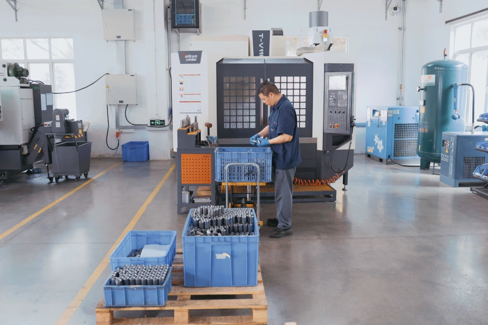 Komaspec machine operator inspecting CNC machined metal parts