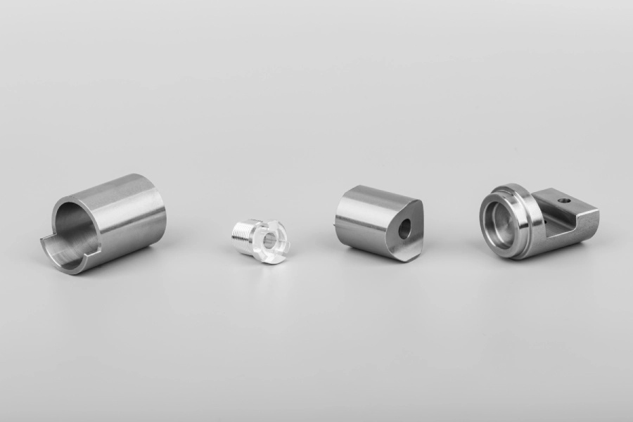 Four distinct parts featuring threads and bores created via CNC machining
